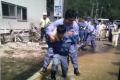 Parliamentary vice minister for reconstruction Shunsuke Mutai being carried by an official during his visit to flood affected regions. - Sakshi Post