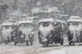 Autorickshaws making their way through a snow-clad road in Srinagar. - Sakshi Post