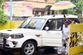 Pilli Sattibabu getting down from the car and the security guard holding an umbrella - Sakshi Post