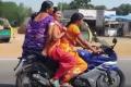 A saree-clad woman triple riding a sports bike - Sakshi Post