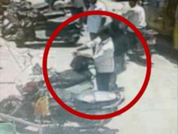 Passersby picking up the cash bag on Besant road, on Monday. - Sakshi Post